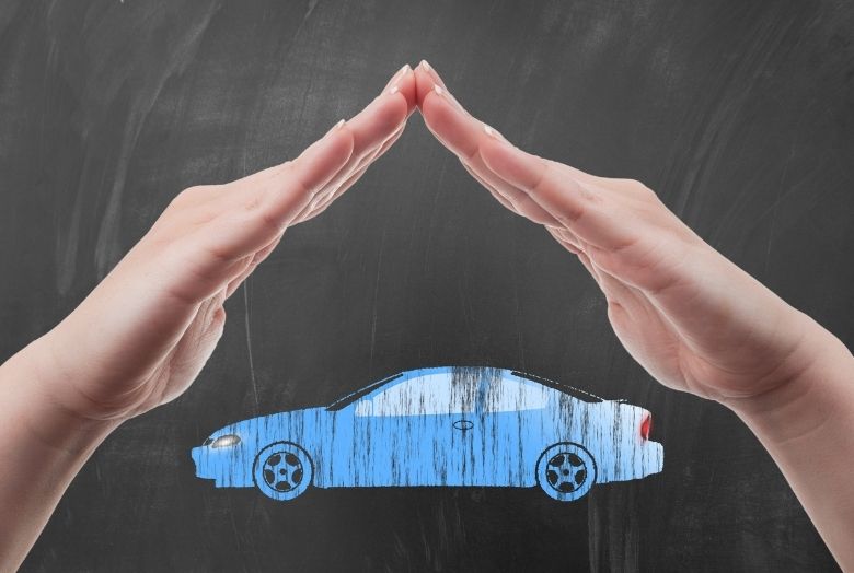 duas mãos unidas formando uma casa para proteger um carro em miniatura azul