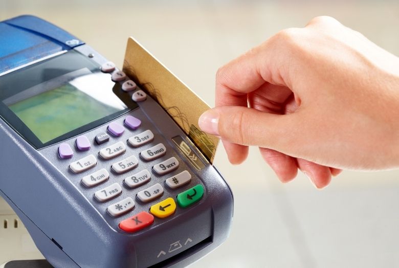 Cartão sendo passado em uma máquina de crédito.