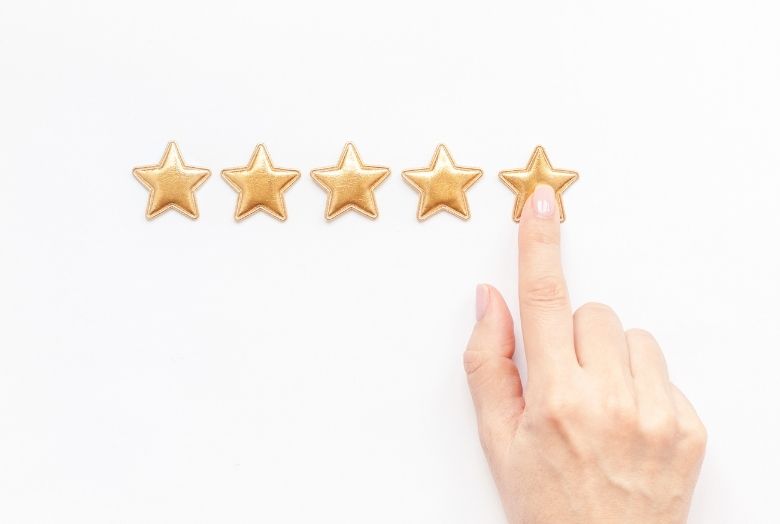uma mão marcando cinco estrelas douradas