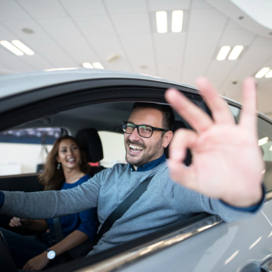 happy-customer-buying-new-car-at-dealership