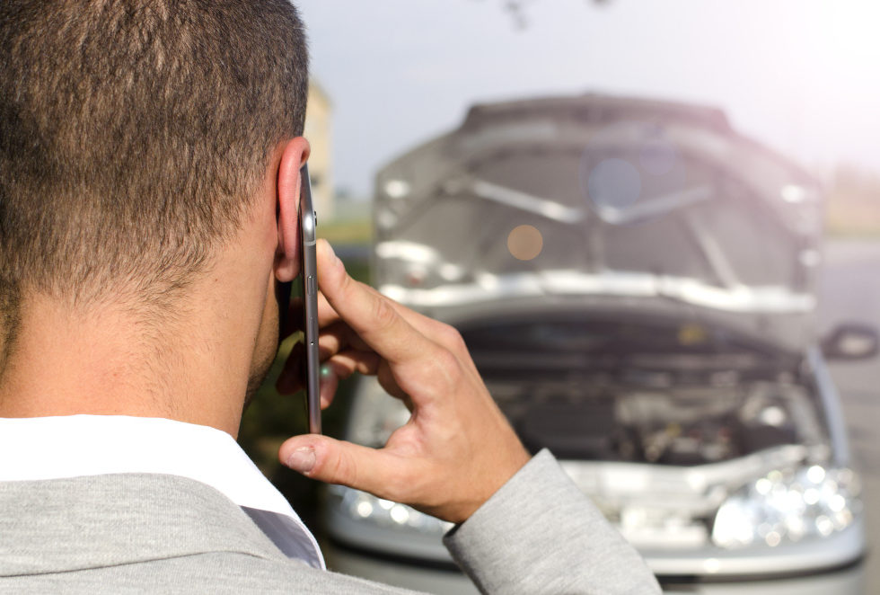 man-standing-by-the-broken-vehicle-calling-tow-service