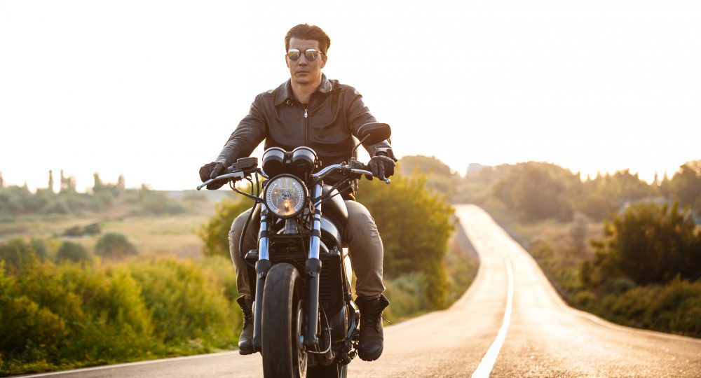 young-handsome-man-riding-on-motorbike-at-countryside-road